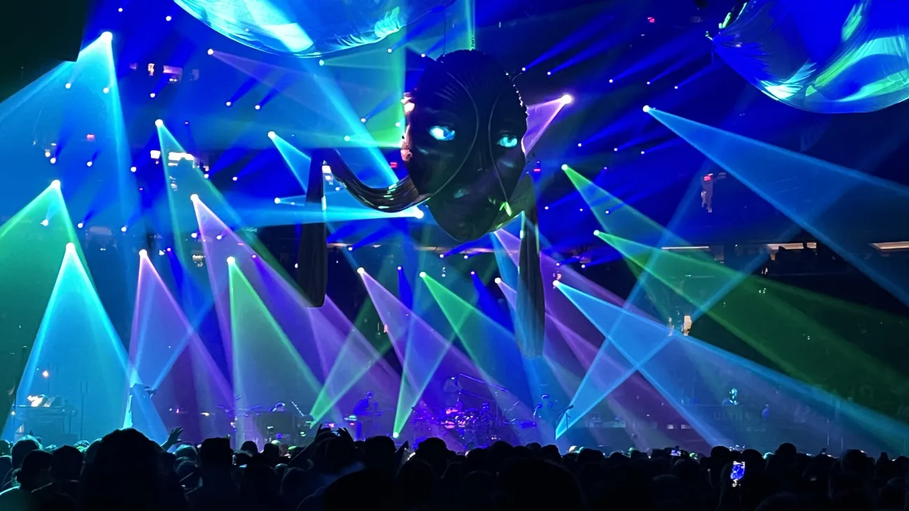 Phish on stage at Madison Square Garden bathed in green and purple light. 